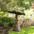 Weather-resistant garden mushroom decoration with natural stone-inspired design in a landscaped garden.