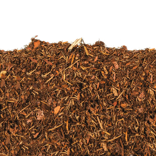 Close-up of natural shredded pine mulch with rich color and fibrous texture for garden beds and pathways